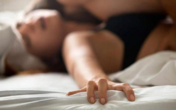 Mulher sorrindo no quarto representando autoconhecimento e comunicação no sexo.